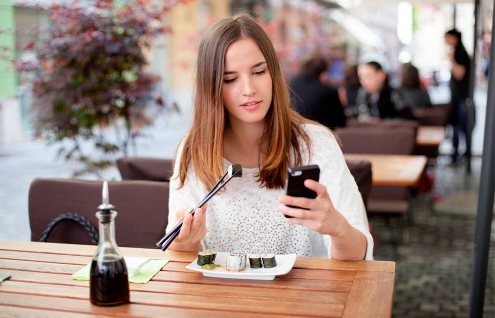 The girl is distracted while eating and eats more than she needs